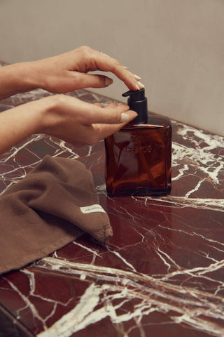 Pumping Saardé hand wash from an amber glass bottle